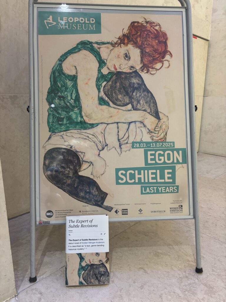 Kirsten Menger-Anderson's novel The Expert of Subtle Revisions with a sign advertising the Egon Schiele Last Years show at the Leopold Museum.